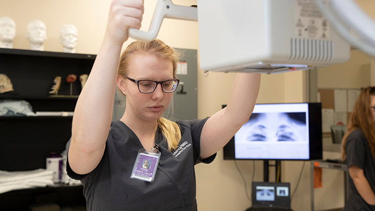 Radiography student using equipment.