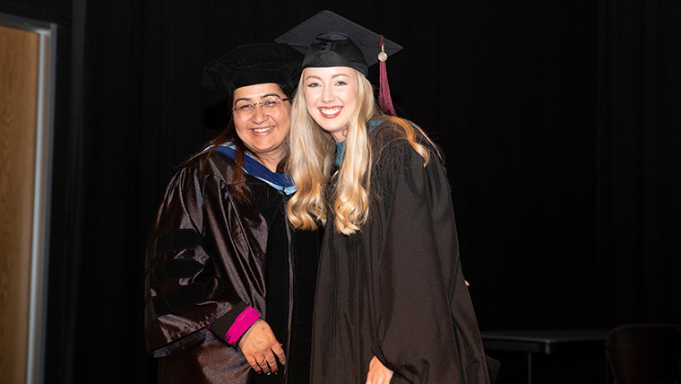 Student and professor at commencement ceremony for occupational therapy.