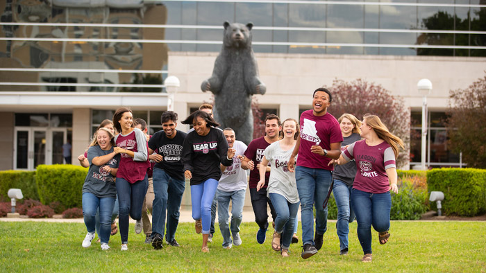 Students on campus with the PSU Bear in the background.