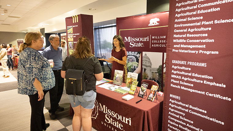 Academic representative talking to visiting student and parents