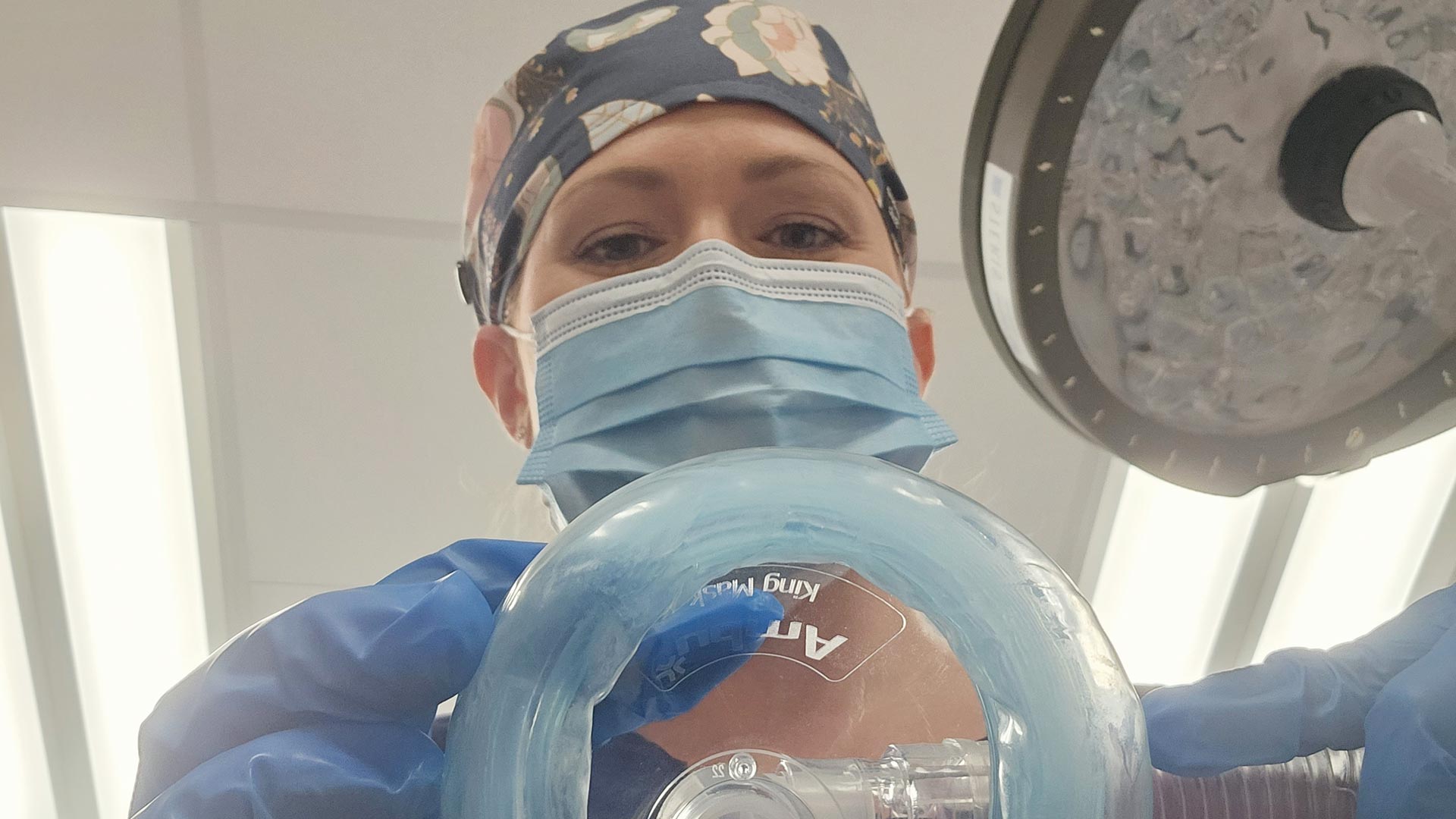 An anesthesia student wearing a surgical mask looks into the cam in the operating room.