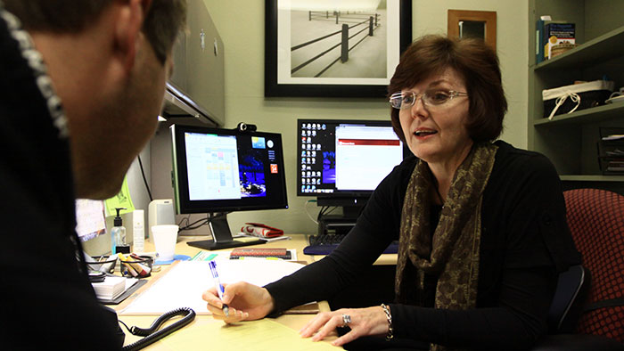 An advisor meets with a student in their office