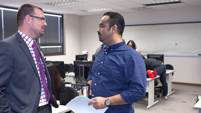 Two people having a discussion in a classroom