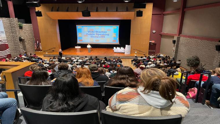 Students watching a presentation in a large auditorium