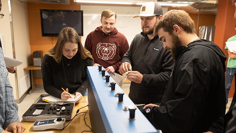 Civil engineering students recording results during a lab exercise.