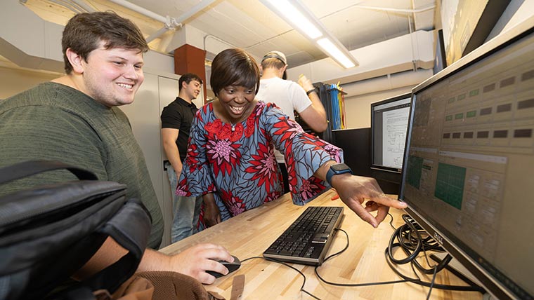 Dr. Theresa Odun-Ayo helps a student during an electrical engineering lab.