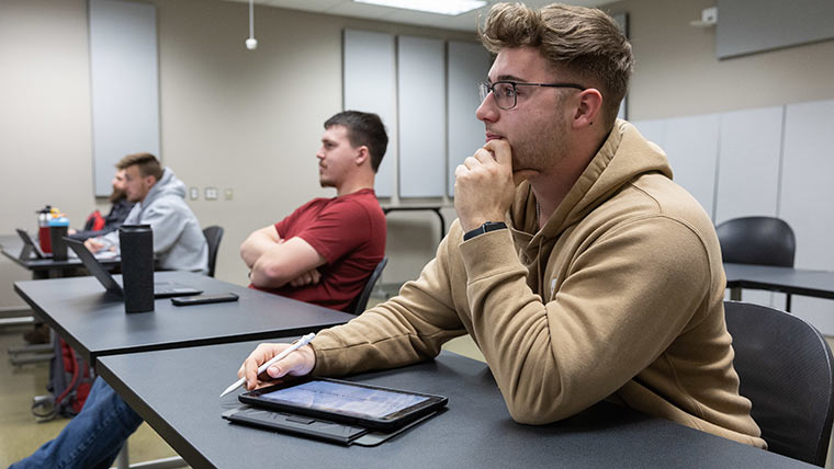 Engineering students sitting in class listening to a professor's lecture.