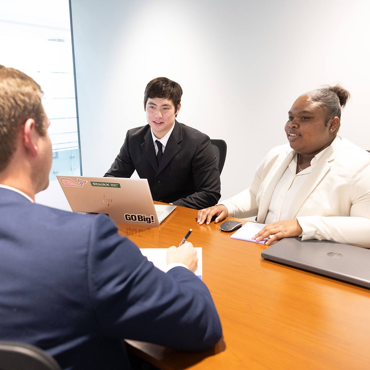 Two financial planning students helping a client during a session at Bear Essentials.