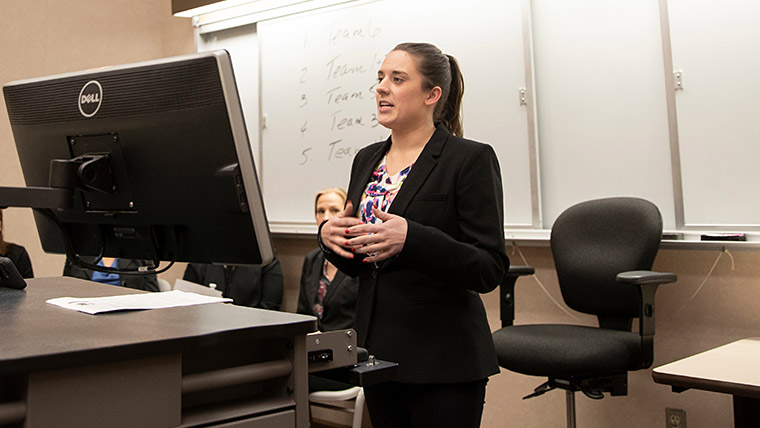 A Missouri State student giving a presentation in front of a classroom.