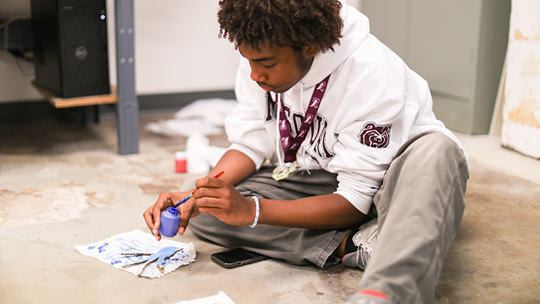 Student at MFAA 2024 sits and paints