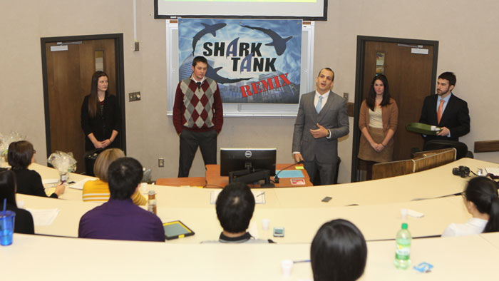 A group of five marketing students give a Shark Tank presentation in class.