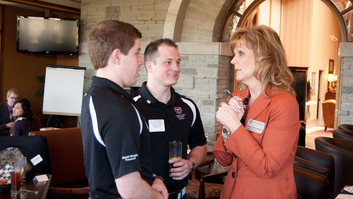 Three Missouri State faculty engage in a discussion at an event.