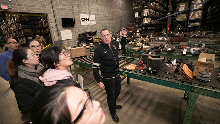 Author Barry Cobb leads a group of students a tour of an industrial supply facility.