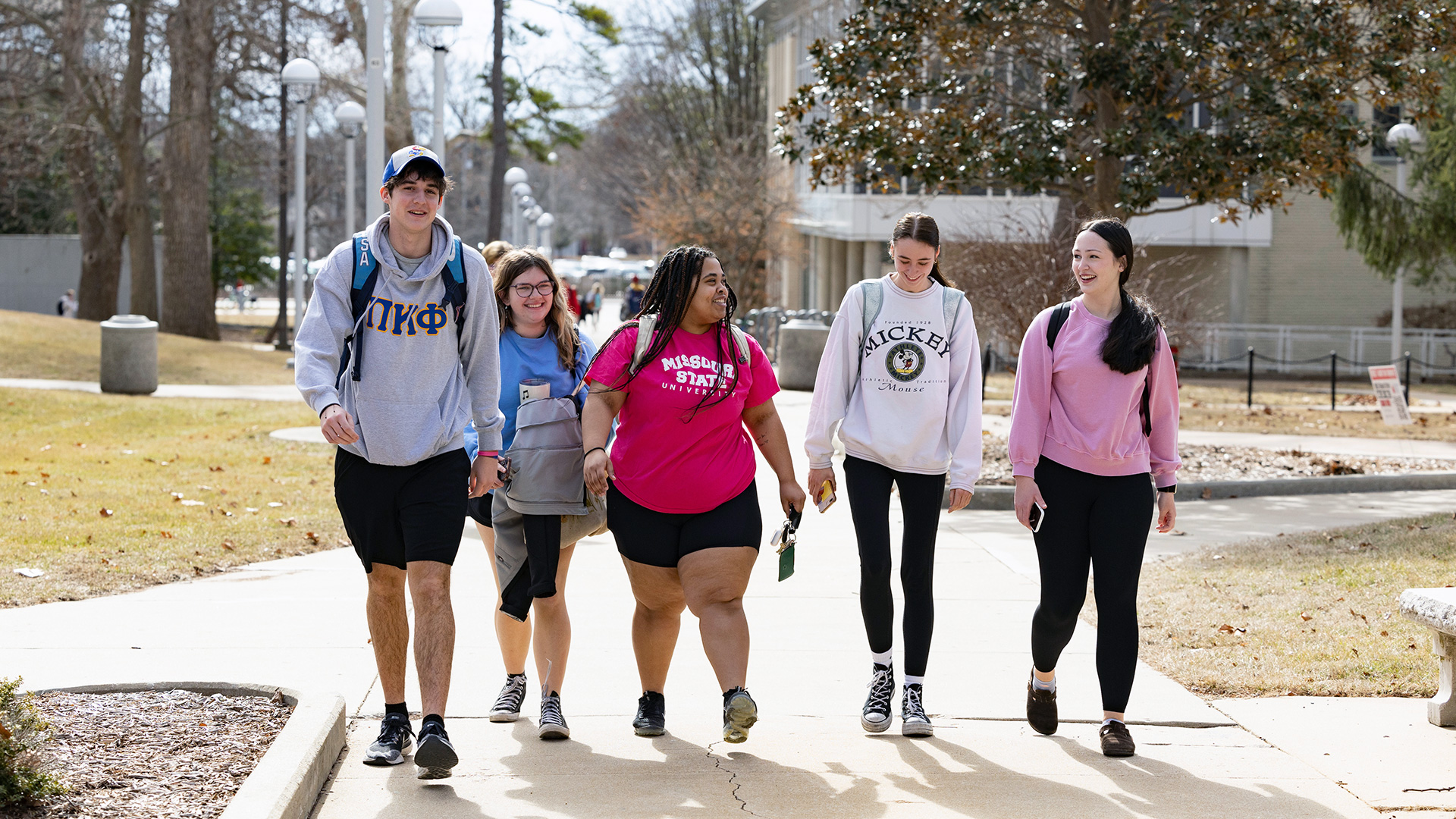 Smiling Missouri State students walking together on campus.