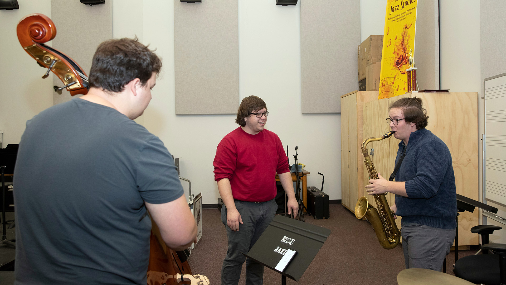 Three students playing jazz instruments in studio