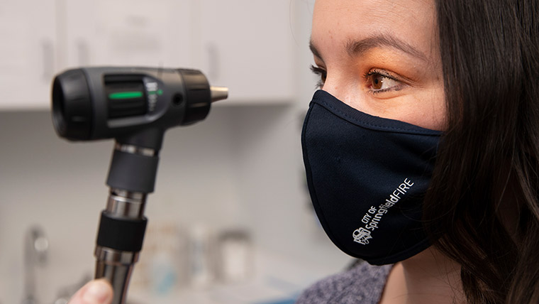 Checking the patient's eyes.