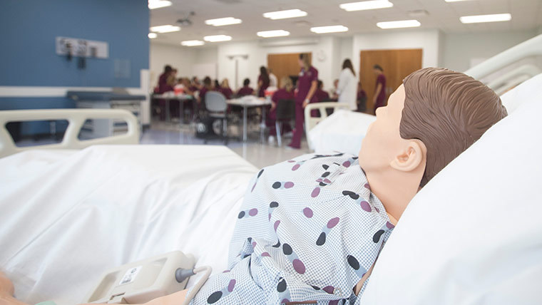 Fake patient laying in hospital bed.