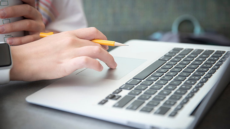 Student typing on a laptop.