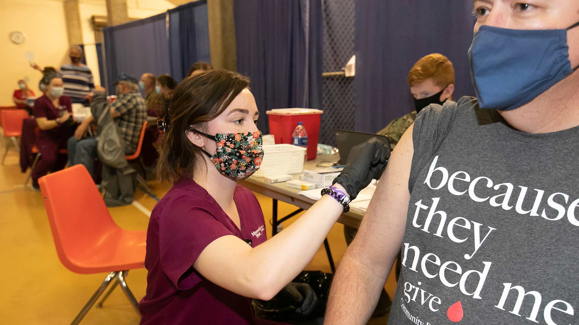 A student nurse provides a vaccine to a patient during a COVID-19 vaccination event.