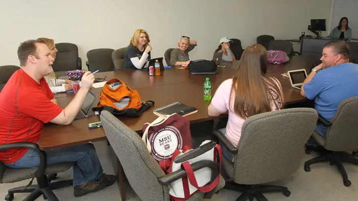 Individuals interacting around a conference table