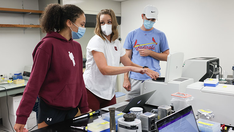 Instructor and students loading lab samples into device.