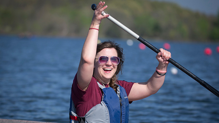 A Missouri State University student rowing a canoe.