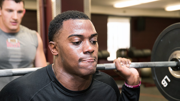 A Missouri State University student lifting weights. 