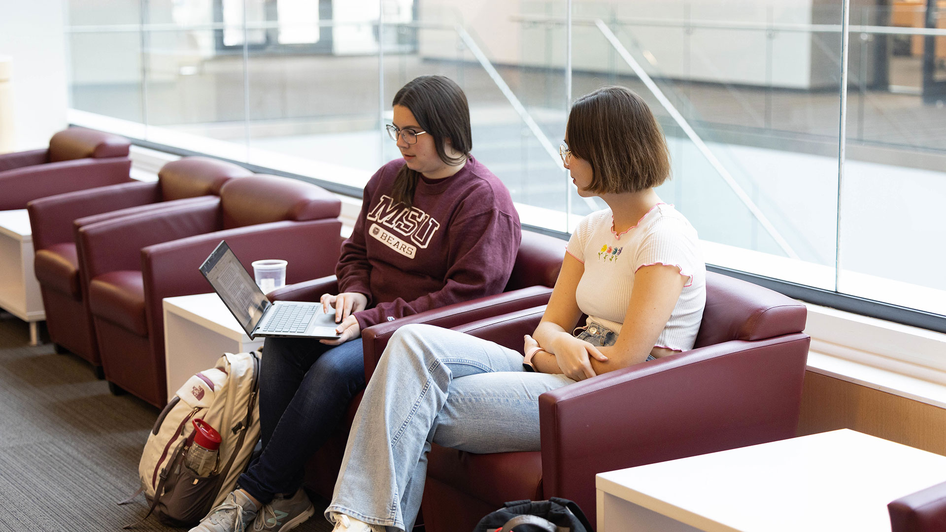 Two Missouri State students are focused on a laptop screen.