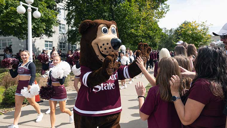 Boomer the bear on campus with students