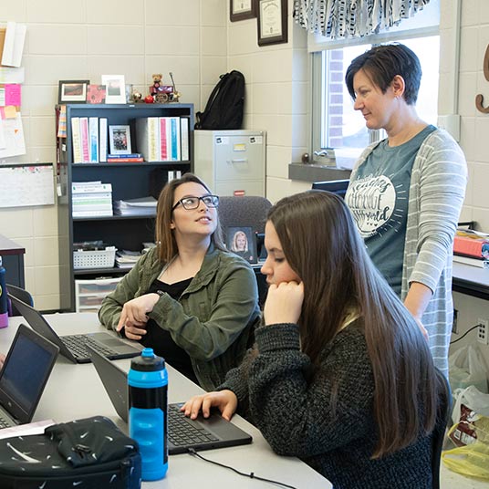 Jennifer Baxter, a Missouri State alumna, assists a student in her family and consumer sciences class at Willard High School.