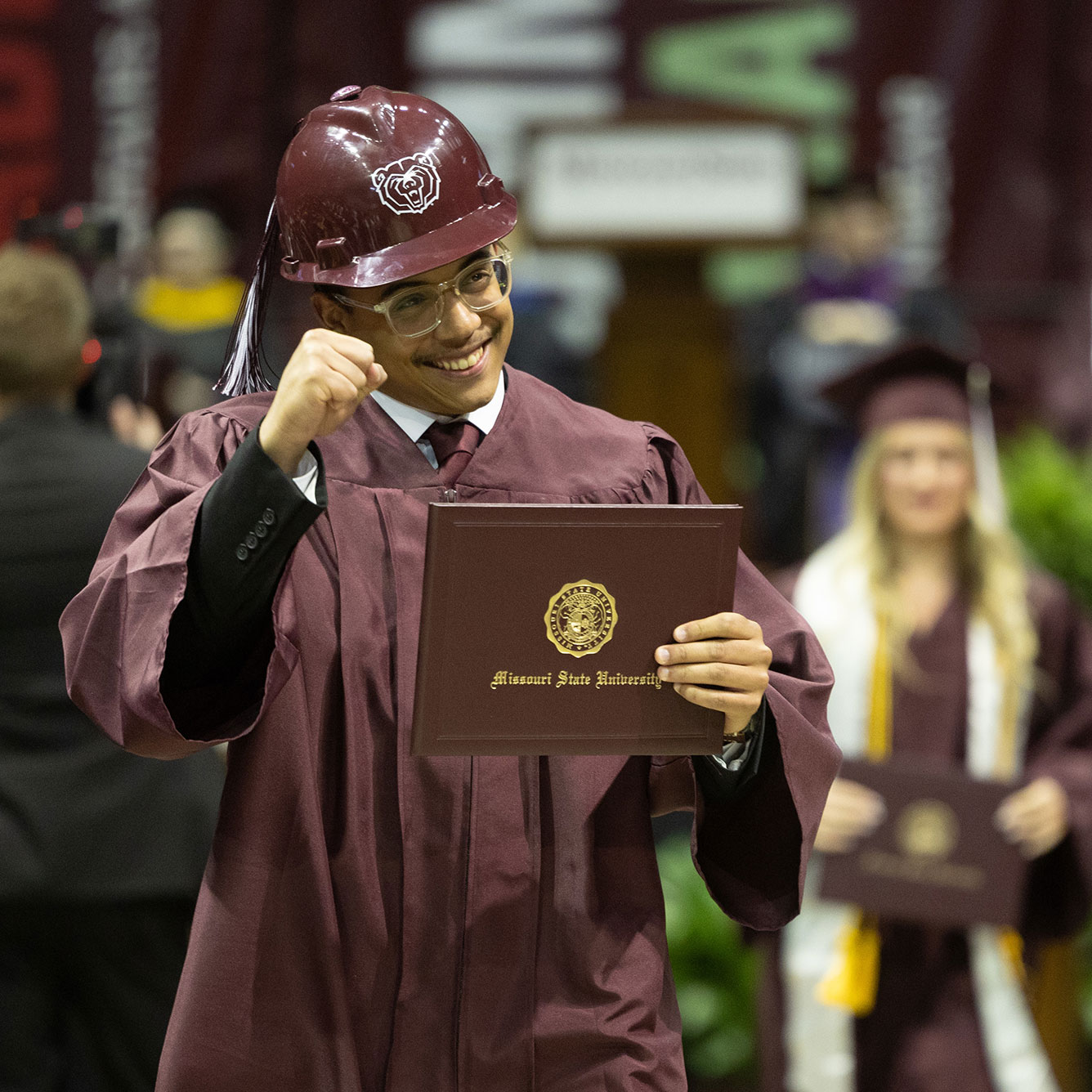 Smiling Missouri State graduate holding his diploma